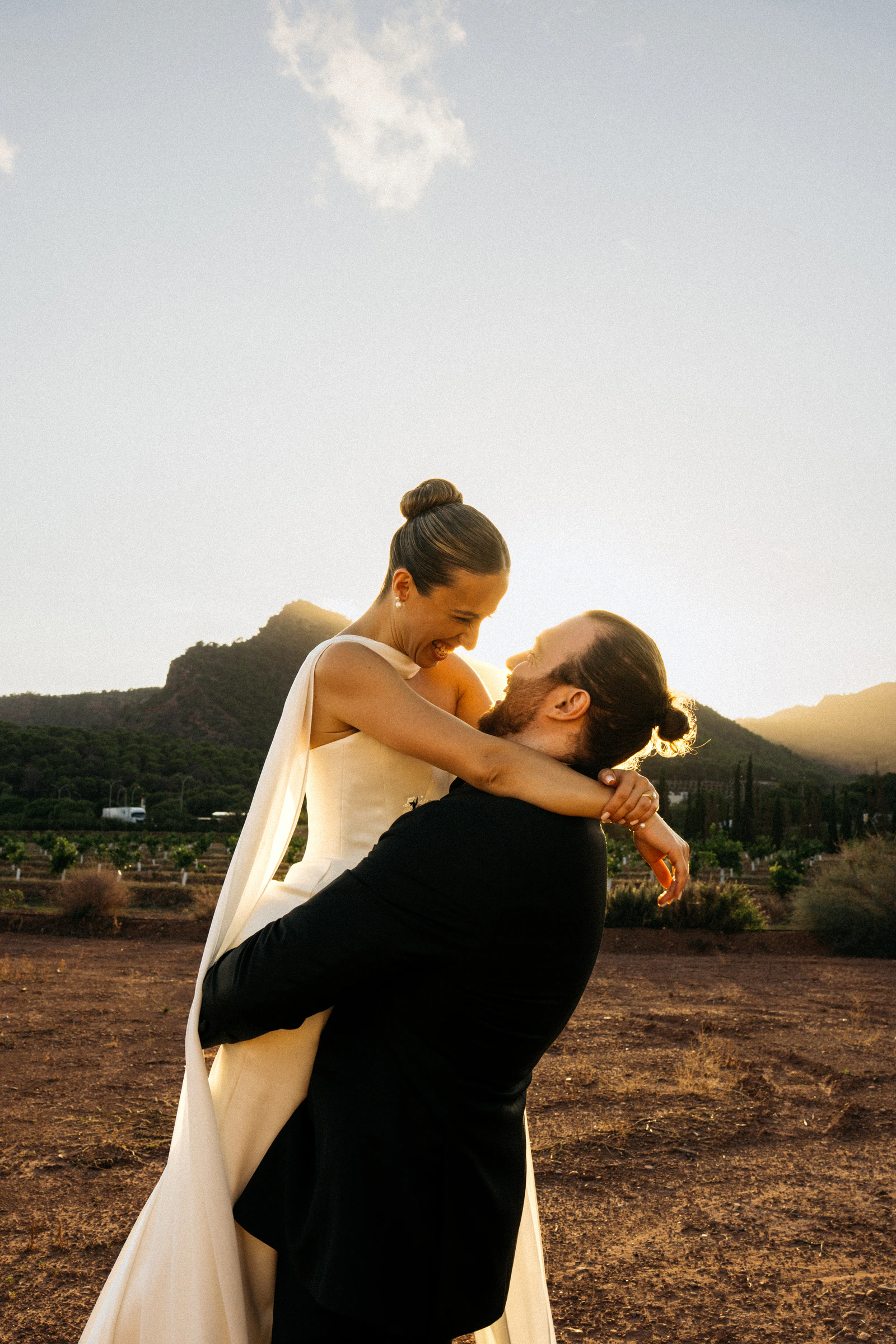 Ada and Liam embracing in the evening light at their Valencia wedding
