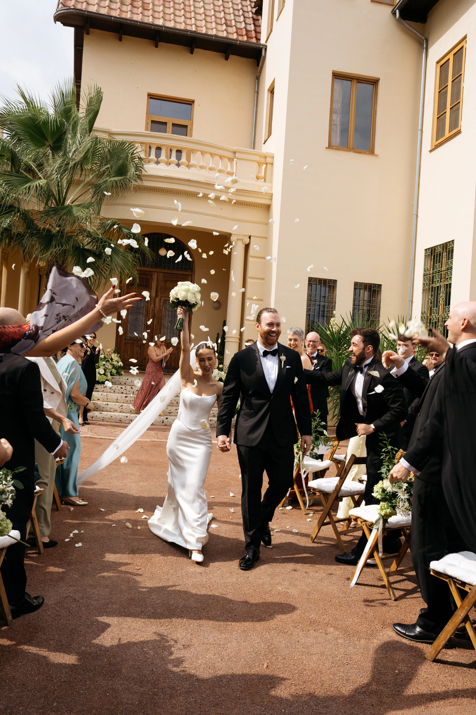 Ada and Liam walking through confetti after their Valencia ceremony