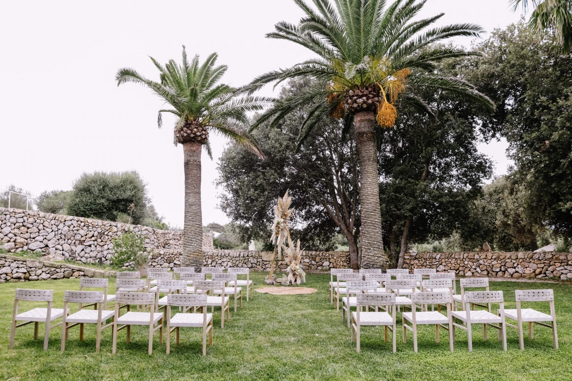 Outdoor ceremony setting prepared beneath palms in Spain