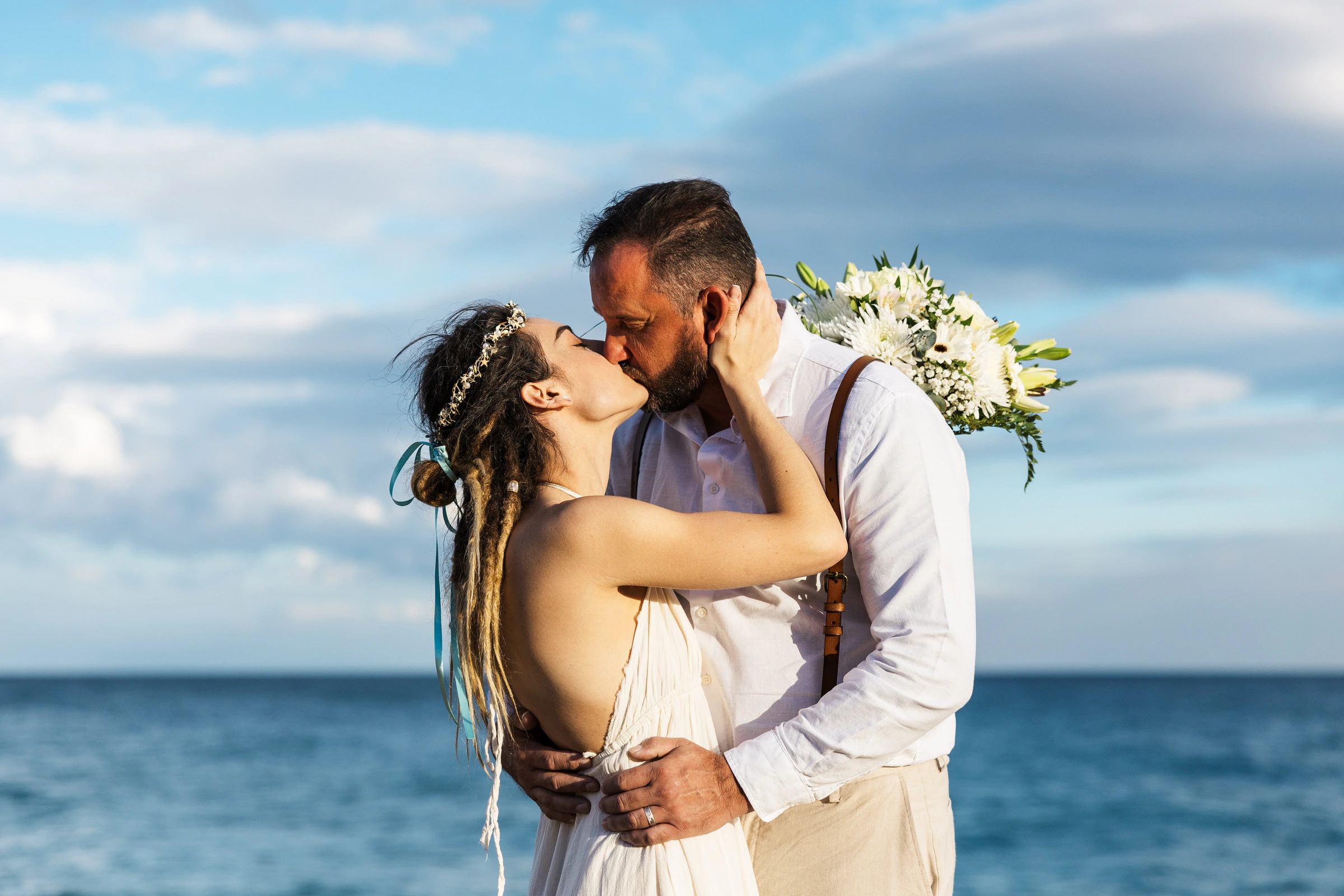 Mary Elaina and John together beside the ocean on their wedding day in Spain