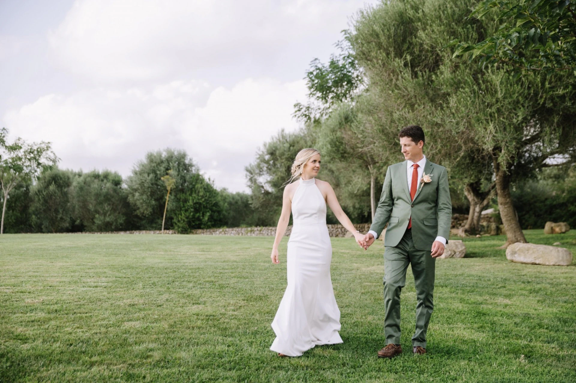 Newlyweds walking through an outdoor wedding setting in Spain