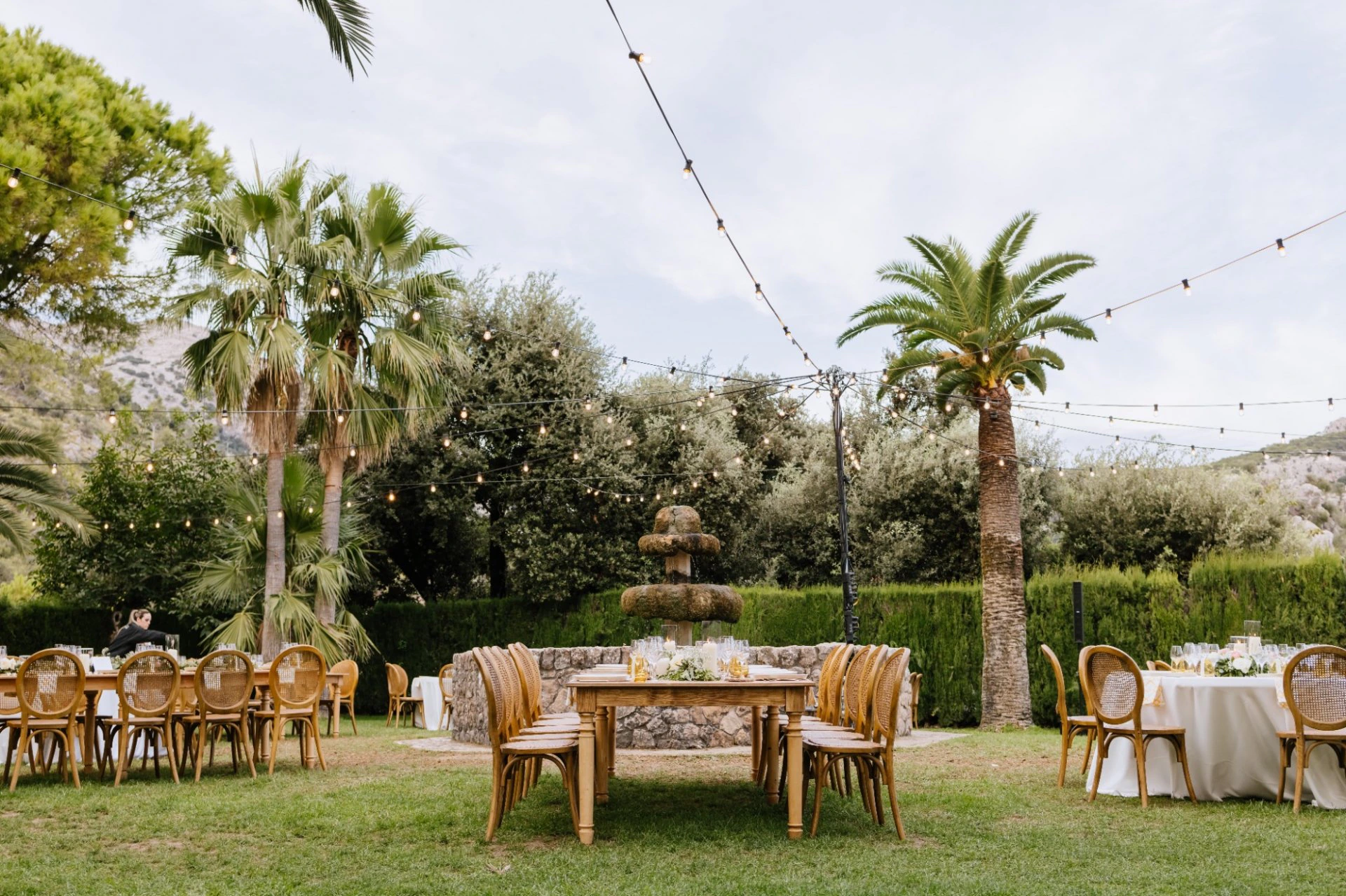 Outdoor wedding tables prepared beneath palms in Spain