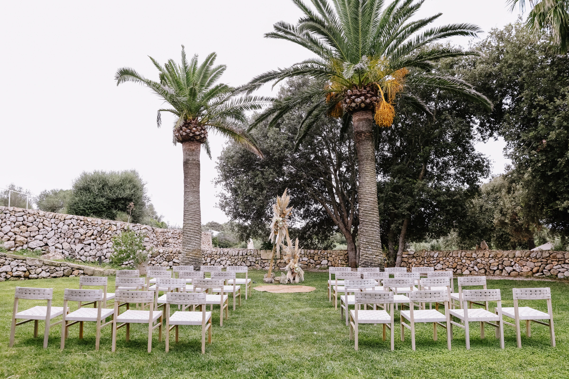 Palm-framed outdoor ceremony prepared for Tessa and Ryan in Menorca